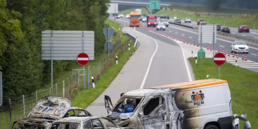 Die Täter hinterliessen bei ihrem Raubüberfall ein Spur der Verwüstung: drei ausgebrannte Fahrzeuge bei der Autobahnausfahrt in La Sarraz VD. (Archivbild)