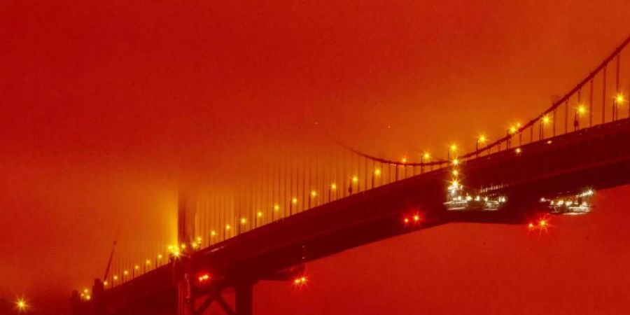 Die Golden Gate Bridge ist infolge der anhaltenden Waldbrände in orangefarbenem Licht zu sehen. Foto: Frederic Larson/AP/dpa