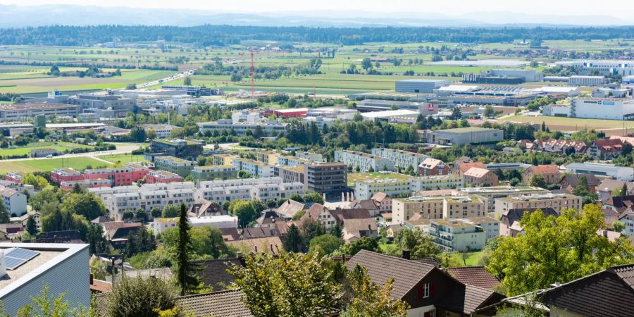 Blick auf Oensingen mit den markanten Gebäuden der Alterssiedlung Roggenpark und der Industrie in der Ebene.