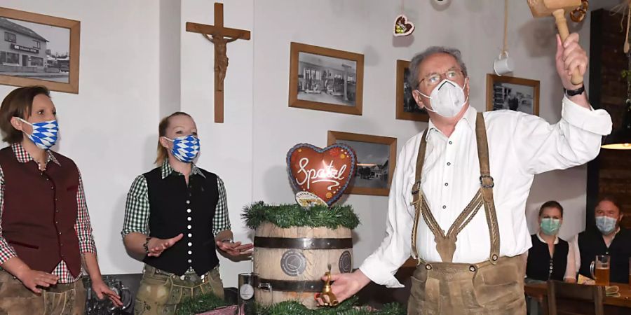Christian Ude (SPD), Ehrenbürger der Stadt München und ehemaliger Münchener Oberbürgermeister, zapft mit Mund-Nasen-Schutz beim Anstich im Schillerbräu das erste Fass an. Foto: Felix Hörhager/dpa