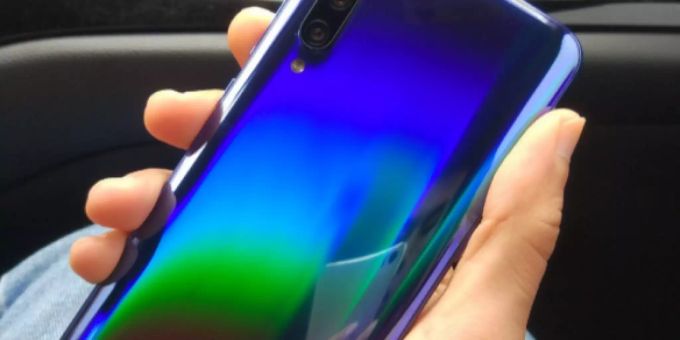 Ein Teilausschnitt des neues Handy-Modells des Herstellers Xiaomi. Das Handy leuchtet regenbogenfarben. Xiaomi Mi 9