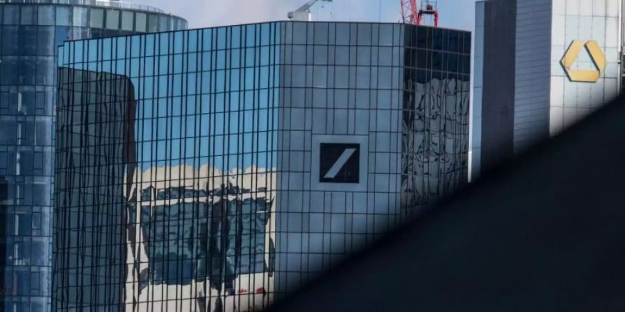Die Zentralen der Commerzbank und der Deutschen Bank ragen hinter einem Hausdach in der FRankfurter City hervor. Foto: Boris Roessler