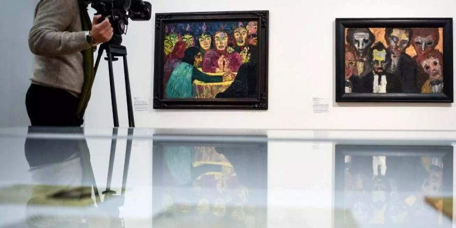 Ein Mann filmt im Hamburger Bahnhof der Berliner Nationalgalerie die Werke «Pfingsten» und «Sechs Herren» von Emil Nolde. Foto: Britta Pedersen