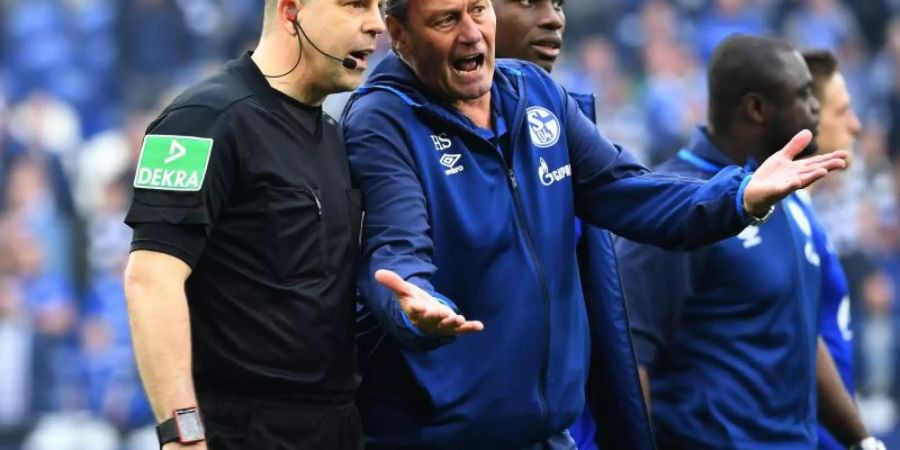 Huub Stevens diskutiert aufgeregt nach dem 1:2 in Frankfurt mit Schiedsrichter-Assistent Christian Gittelmann (l). Foto: Ina Fassbender