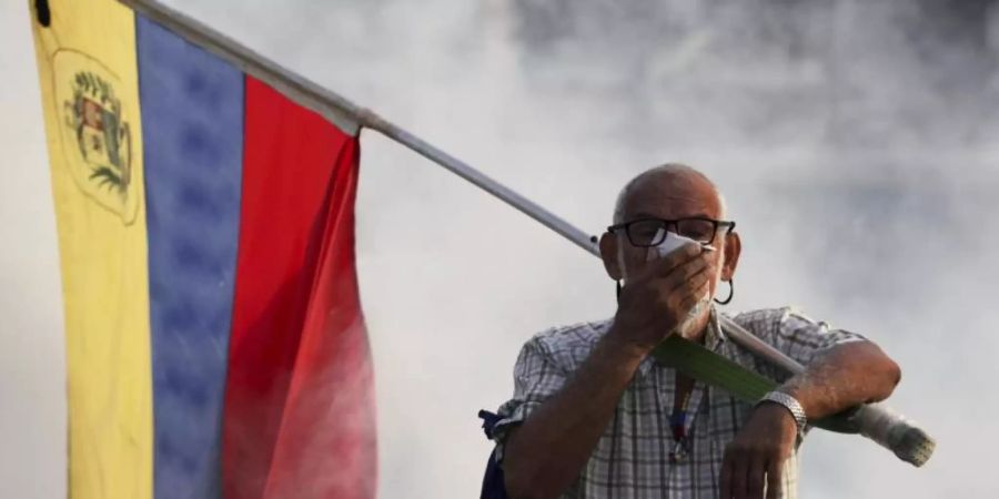 Demonstrant mit venezolanischer Flagge auf der Strassen von Caracas. Die USA und Russland suchen das Gespräch bezüglich Venezuela. Foto: Boris Vergara/AP