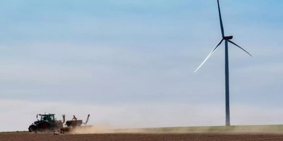 Ein Traktor fährt über einen trockenen Acker in Bayern und zieht eine Staubwolke hinter sich her. Foto: Peter Kneffel