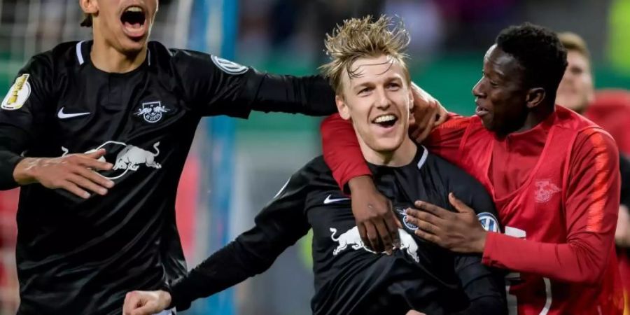 Emil Forsberg (M) jubelt mit Yussuf Poulsen (l) und Amadou Haidara über sein Tor zum 3:1. Foto: Axel Heimken