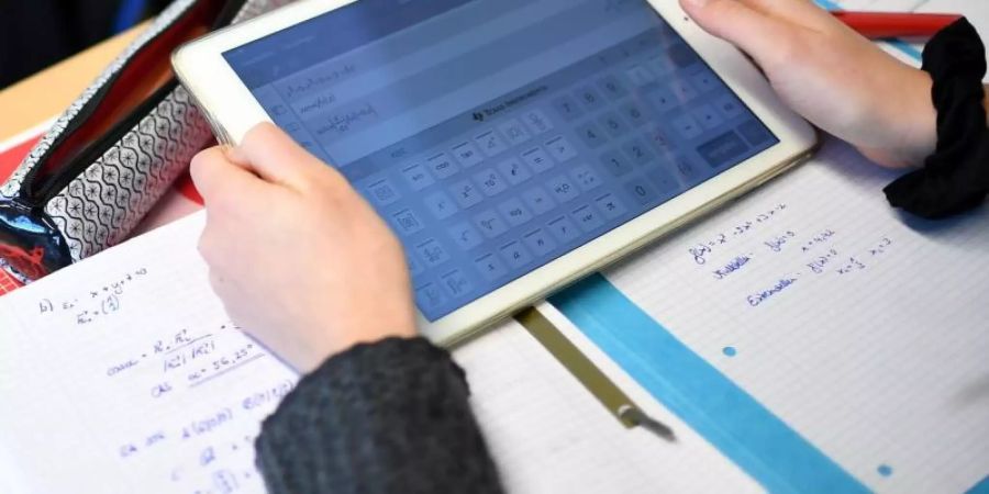 Ein Schüler eines Gymnasiums errechnet eine Gleichung mit einem iPad im Matheunterricht. Foto: Britta Pedersen