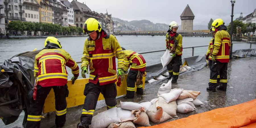 Die Feuerwehr der Stadt Luzern sichert die Bahnhofstrasse entlang der Reuss mit Schutzschläuchen aufgrund der angekündigten Regenfälle der nächsten Tage, am Dienstag, 13. Juli 2021, in Luzern.