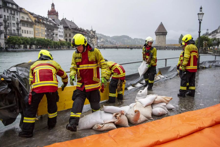 Einsatzkräfte versuchen mit allen Mitteln, das Wasser vom Land fernzuhalten.