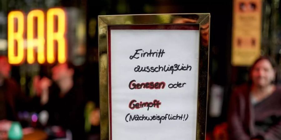 Vor einer Bar im Hamburger Stadtteil St. Georg steht ein Hinweisschild, welches auf den Einlass nach der 2G-Regel hinweist. Foto: Axel Heimken/dpa