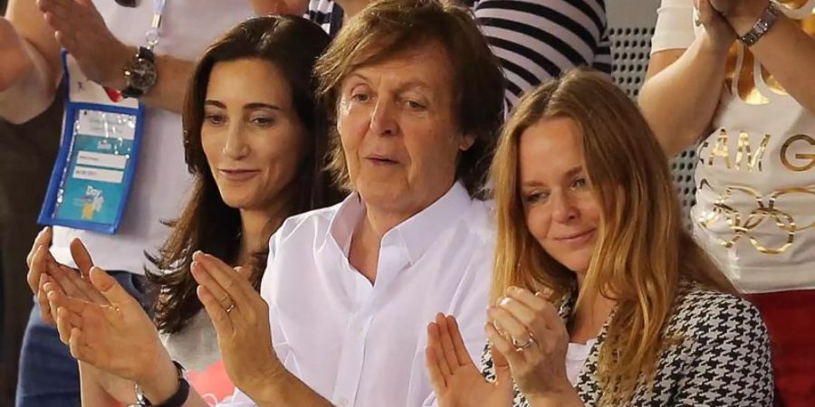 Paul McCartney (M) applaudiert mit seiner Frau Nancy Shevell und seiner Tochter Stella (r). (Archivbild). Foto: Christian Charisius/dpa