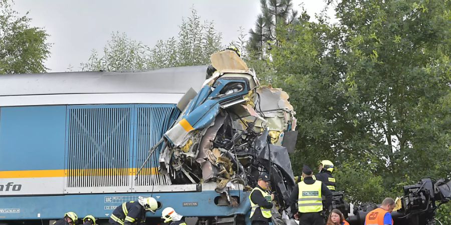 Einsatzkräfte an einem zerstörten Waggon bei der Ortschaft Milavèe. Foto: Chaloupka Miroslav/CTK/dpa