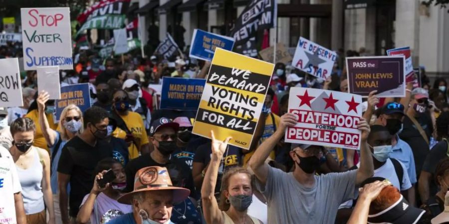 Demonstranten protestieren in Washington DC gegen Wahlrechtsreformen. Das Parlament im US-Staat Texas hat umstrittene Wahlrechtsänderungen beschlossen. Foto: Jose Luis Magana/AP/dpa