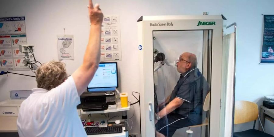 Reinhard Janzen sitzt zur Überprüfung seiner Lungenfunktion in einem Bodyplethysmographen in der Reha-Klinik Bad Rothenfelde. Foto: Sina Schuldt/dpa