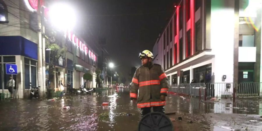 Ein Feuerwehrmann steht in einer überfluteten Strasse in Ecatepec. Aufgrund starker Regenfälle am Montag kam es im Zentrum von Ecatepec im Bundesstaat Mexiko zu Überschwemmungen. Foto: El Universal/El Universal via ZUMA Press Wire/dpa