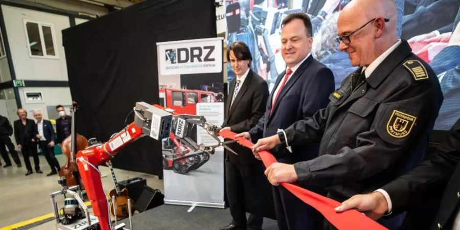 Ein Roboter schneidet zur Eröffnung des «Living Lab» des Deutschen Rettungsrobotik Zentrums ein rotes Band durch. Foto: Dieter Menne/dpa