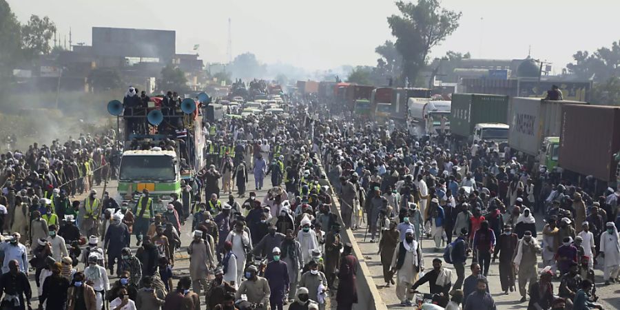 Anhänger der radikal-islamistischen Partei Tehreek-e Labbaik Pakistan (TLP) nehmen an einem Protestmarsch in Richtung Islamabad auf einer Landstrasse teil. Foto: K.M. Chaudary/AP/dpa
