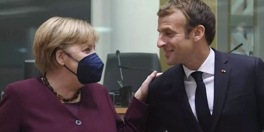 Emmanuel Macron, Präsident von Frankreich, begrüsst Bundeskanzlerin Angela Merkel (CDU) am zweiten Tag eines EU-Gipfels. Foto: John Thys/Pool AFP/AP/dpa