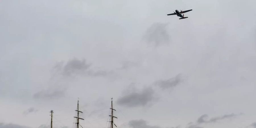 Das Segelschulschiff «Gorch Fock» fährt auf die Kieler Förde zu, während eine Transall der Bundeswehr das Schiff überfliegt. Foto: Axel Heimken/dpa