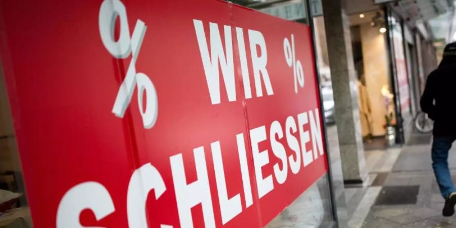 Der Schriftzug «Wir schliessen» steht am Schaufenster eines Geschäftes auf einer Seitenstrasse der Düsseldorfer Königsallee. Foto: Martin Gerten/dpa