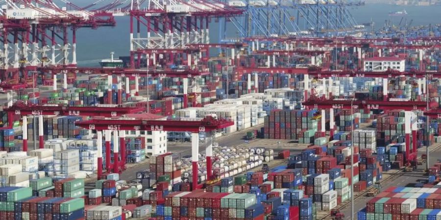 In einem Hafen stehen Container und Containerbrücken. Der Handelskrieg mit den USA setzt Chinas Wirtschaft kräftig zu. Foto: AP