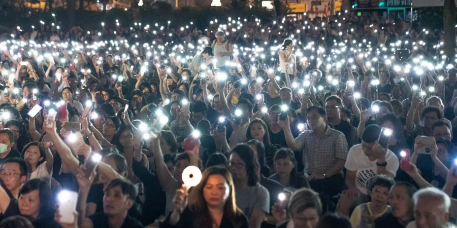 Demonstranten halten Lichter während einer Kundgebung zur Unterstützung von Gegnern des Auslieferungsgesetzes hoch.