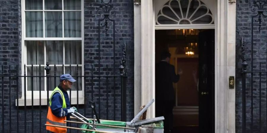 Ein Strassenkehrer arbeitet vor der 10 Downing Street, dem Amtssitz von Premierminister Boris Johnson. Foto: Victoria Jones/PA Wire