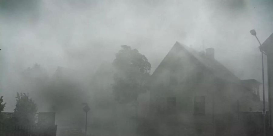 Nichts mehr zu sehen: Ein starkes Gewitter mit Sturmböen zieht durch die Strassen der südhessischen Stadt Langen. Foto: Frank Rumpenhorst