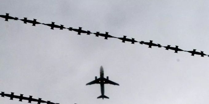 Ein Flugzeug mit Stacheldraht im Vordergrund. Flugzeug