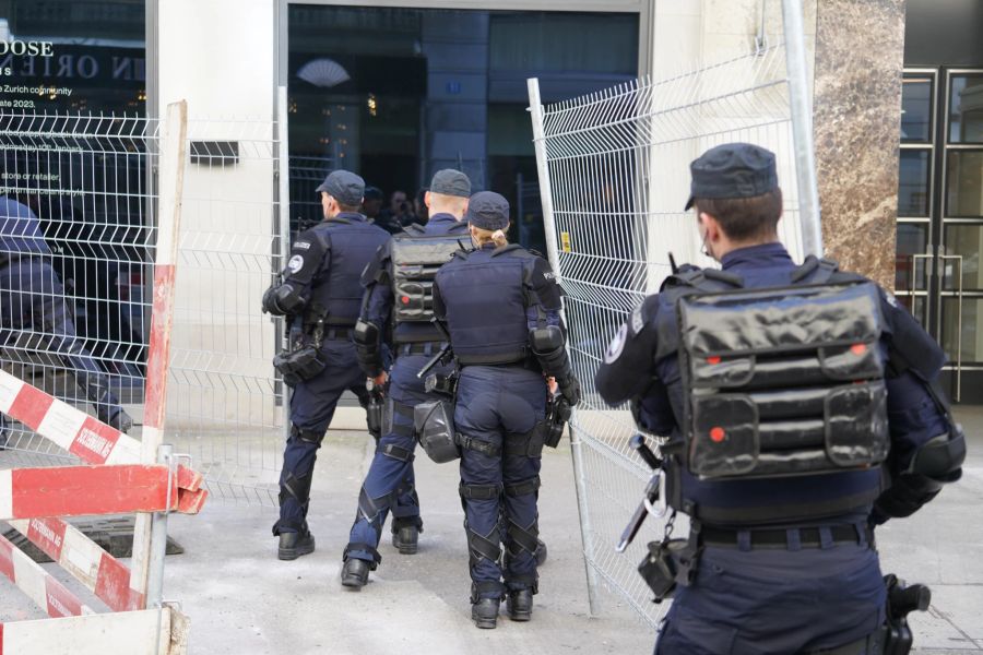 Polizisten stellen in der Poststrasse Zäune auf.