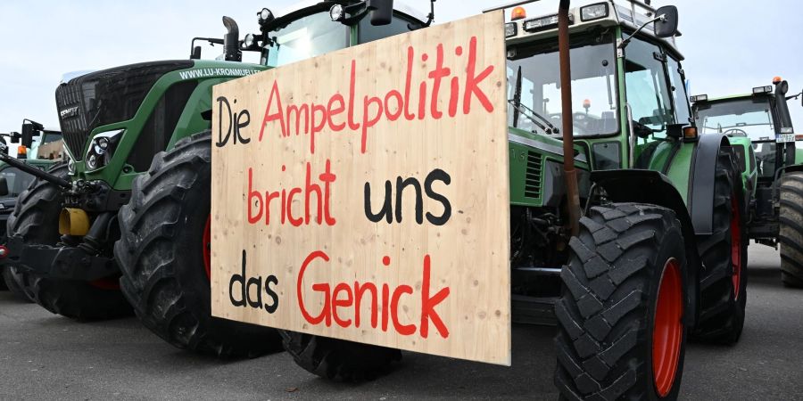 Mit Traktoren und einem Transparent mit der Aufschrift: «Die Ampelpolitik bricht uns das Genick» demonstrieren Landwirte auf dem Cannstatter Wasen gegen die Agrarpoltik der Bundesregierung.