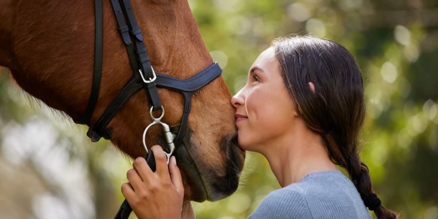 Frau liebevoll mit Pferd