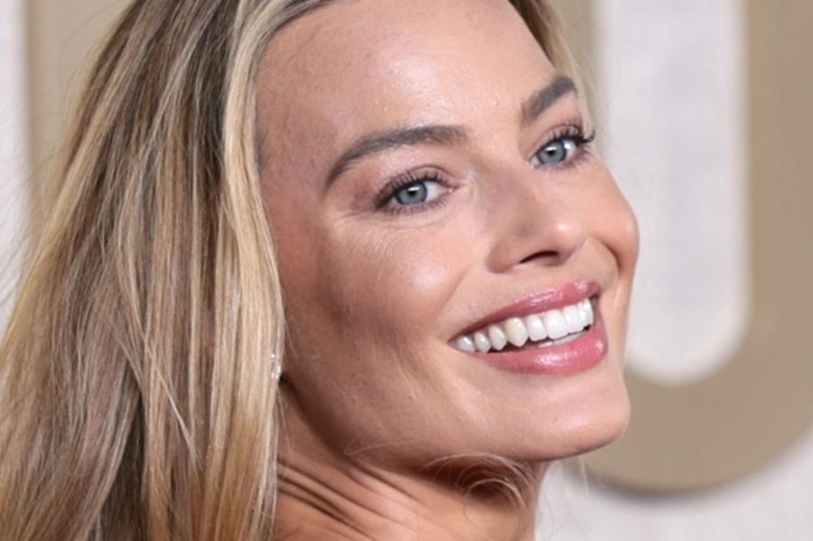 Margot Robbie strahlt auf dem roten Teppich.