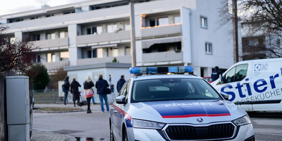 Ein Polizeiauto steht vor dem Tatort. Foto: Max Slovencik/APA/dpa