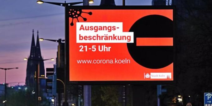 Auf einer Anzeigetafel in Köln wird auf die Ausgangsbeschränkung hingewiesen. Foto: Oliver Berg/dpa Auf einer Anzeigetafel in Köln wird auf die Ausgangsbeschränkung hingewiesen. Foto: Oliver Berg/dpa