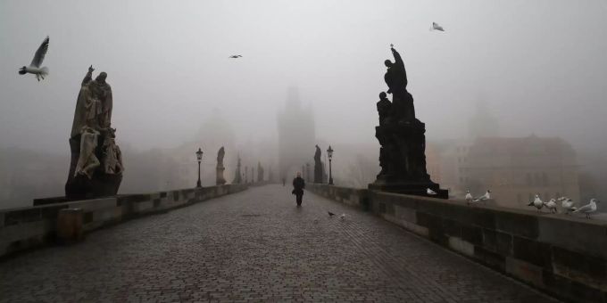 dpatopbilder - 24.02.2021, Tschechien, Prag: Ein Mann geht bei Nebel über die mittelalterliche Karlsbrücke. Die tschechische Regierung hat angekündigt, die restriktiven Massnahmen inmitten eines Anstiegs einer hochansteckenden Variante des Coronavirus weiter zu verschärfen. Coronavirus - Tschechien