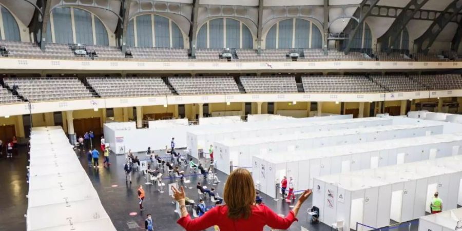 Die Mezzosopranistin Dzuna Kalnina von der Kammeroper Frankfurt/Main singt im Impfzentrum der Festhalle vom Balkon. Foto: Frank Rumpenhorst/dpa Pool/dpa