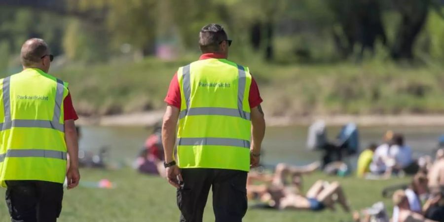 Wie hier am Ufer der Isar wird in München an öffentlichen Orten die Einhaltung der Corona-Regeln kontrolliert. Im Englischen Garten ist es dabei zu einer gewaltsamen Auseinandersetzung zwischen der Polizei und Feiernden gekommen. (Symbolbild). Foto: Peter Kneffel/dpa