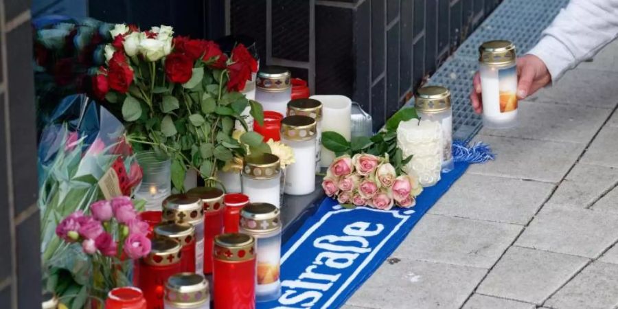 Blumen und Kerzen vor dem Haus in Köln-Mülheim, in dem Willi Herren wohnte. Foto: Henning Kaiser/dpa