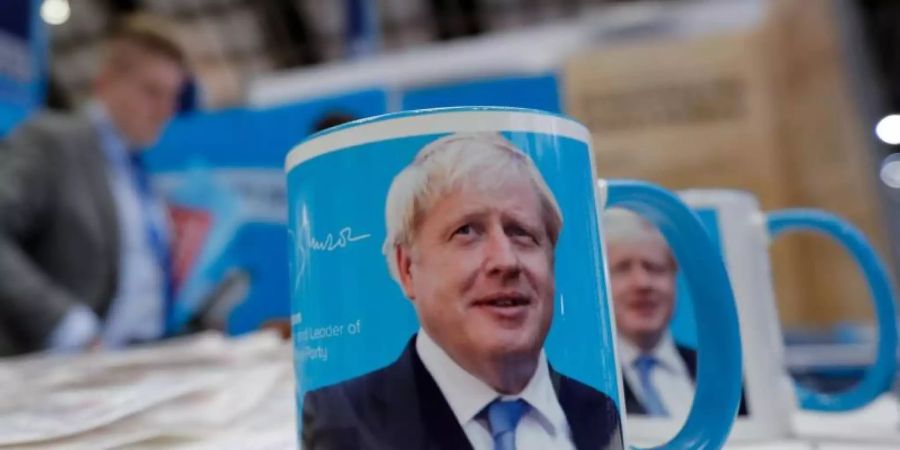 Tassen mit dem Gesicht von Premierminister Boris Johnson auf dem Parteitag. Foto: Frank Augsteink/AP