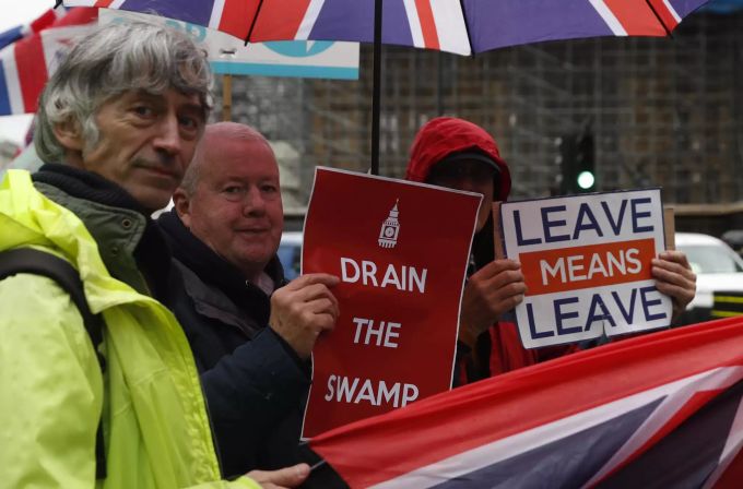 Pro-Brexit Protestierende halten ihre Schilder vor dem Parlamentshaus in London auf. Britain Brexit