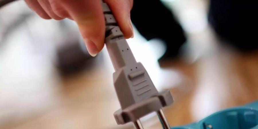 Ein Stecker wird in die Steckdose gesteckt. Foto: Oliver Berg/dpa