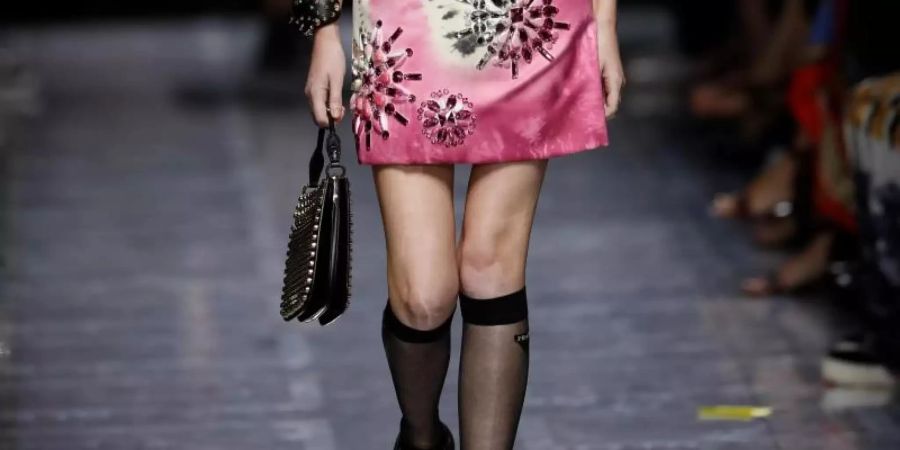 Ein Model trägt Minikleid und knielange Nylonstrümpfe, eine Kreation aus der Damenkollektion von Prada für Frühjahr-Sommer 2019. Foto: Antonio Calanni/AP/dpa