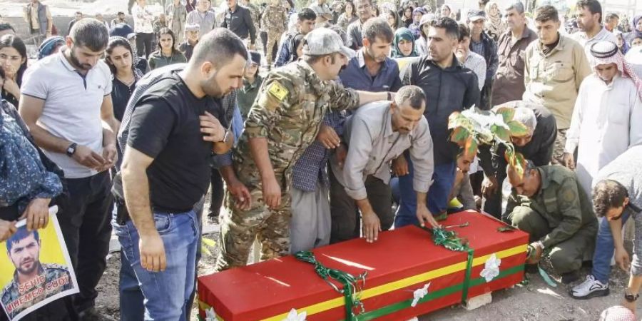 Die Leiche eines Kämpfers der Syrischen Demokratischen Kräfte, der in der Stadt Ras al-Ain im Kampf gegen die türkischen Streitkräfte ums Leben kam, wird beerdigt. Foto: -/Rojava Information Center/dpa