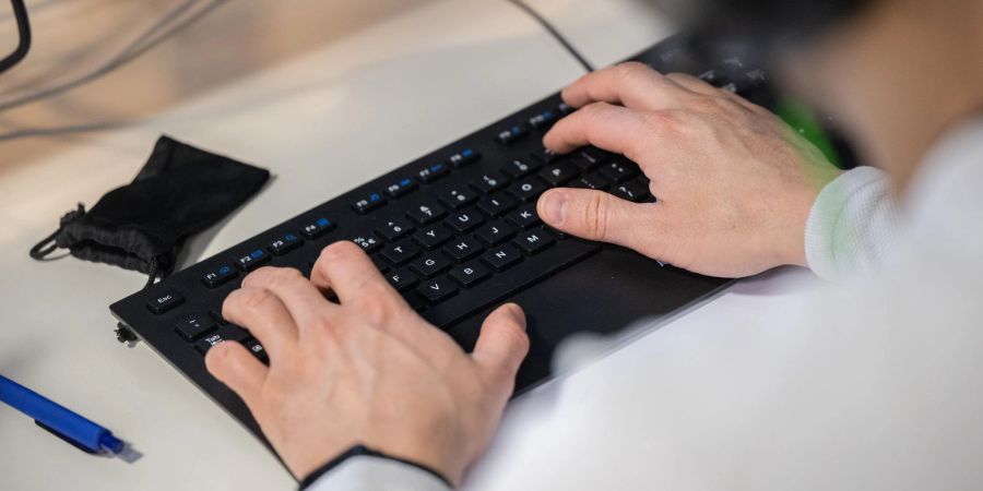 Mann tippt an einer Tastatur