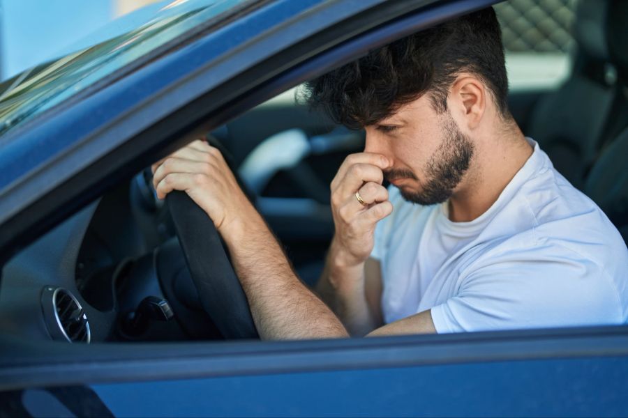 Mann im stinkenden Auto