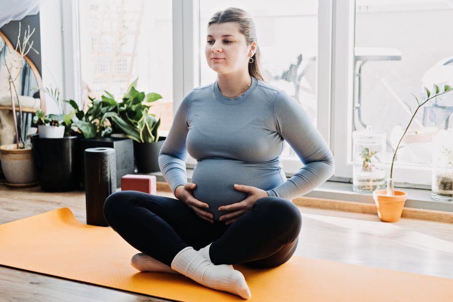 Schwangere Frau auf einer Sportmatte