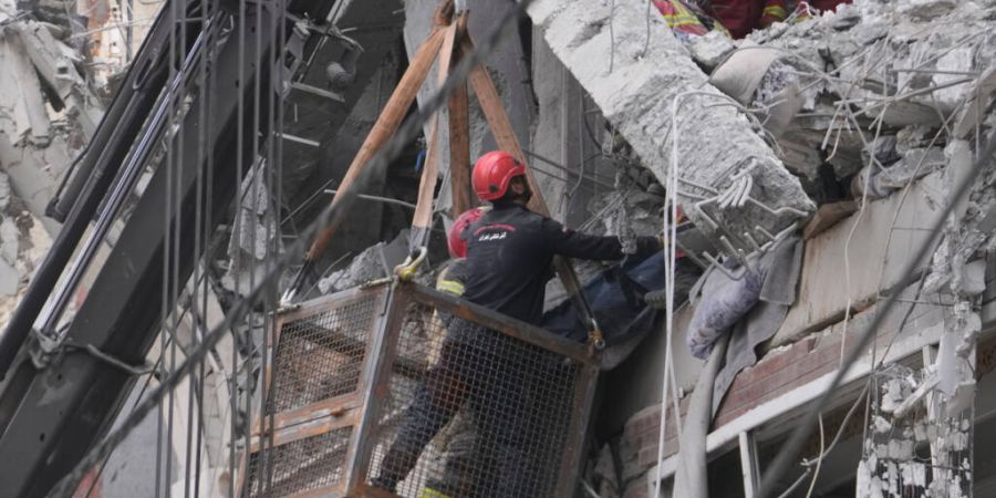 Ersthelfer bergen in Teheran ein Opfer aus einem Wohnhaus, das von einem amerikanisch-israelischen Luftangriff getroffen wurde. Foto: Vahid Salemi/AP/dpa