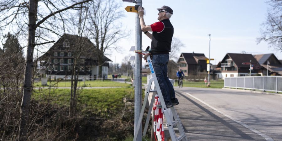 Beny Walker von der Infrastruktur der Zuger Wanderwege putzt Wanderwegtafeln. (Symbolbild)
